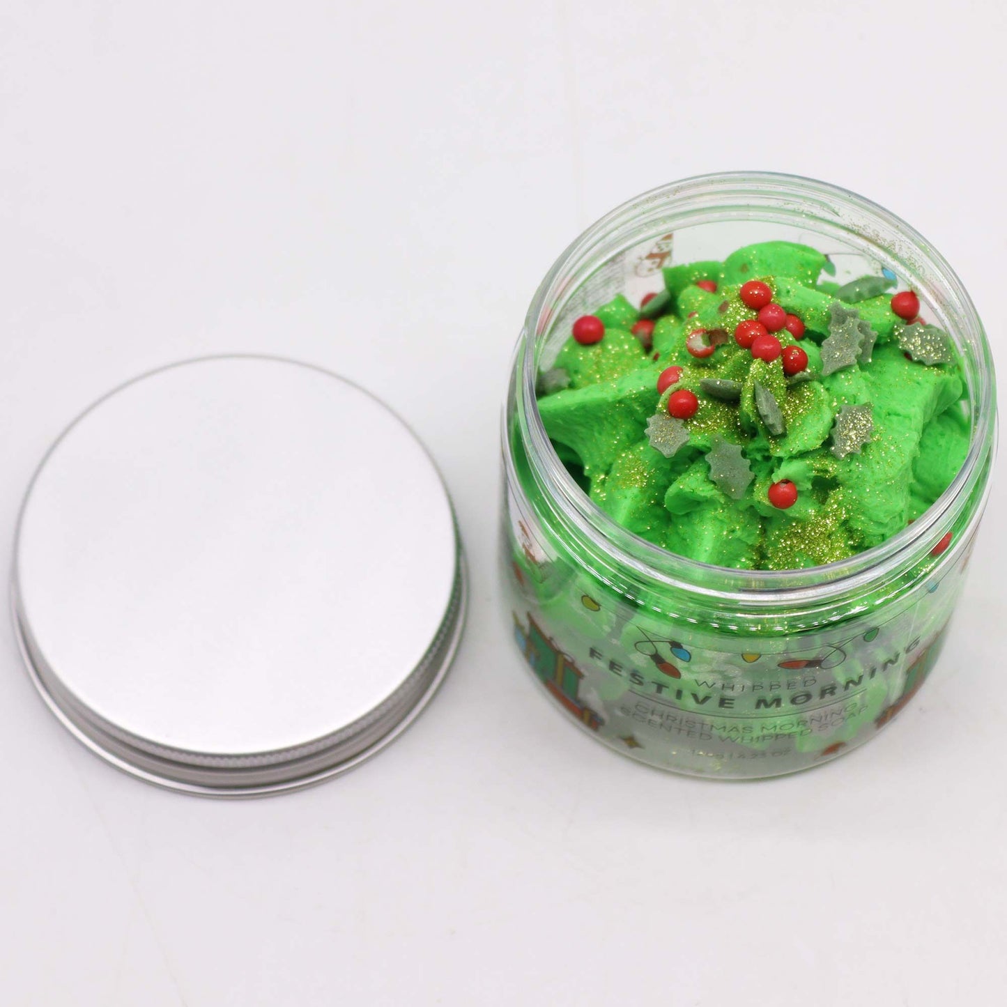 Festive Morning Whipped Soap 120g in a jar, featuring vibrant green whipped texture topped with red and green decorations, perfect for a Christmas gift – Christmas Gift Home Fragrance.