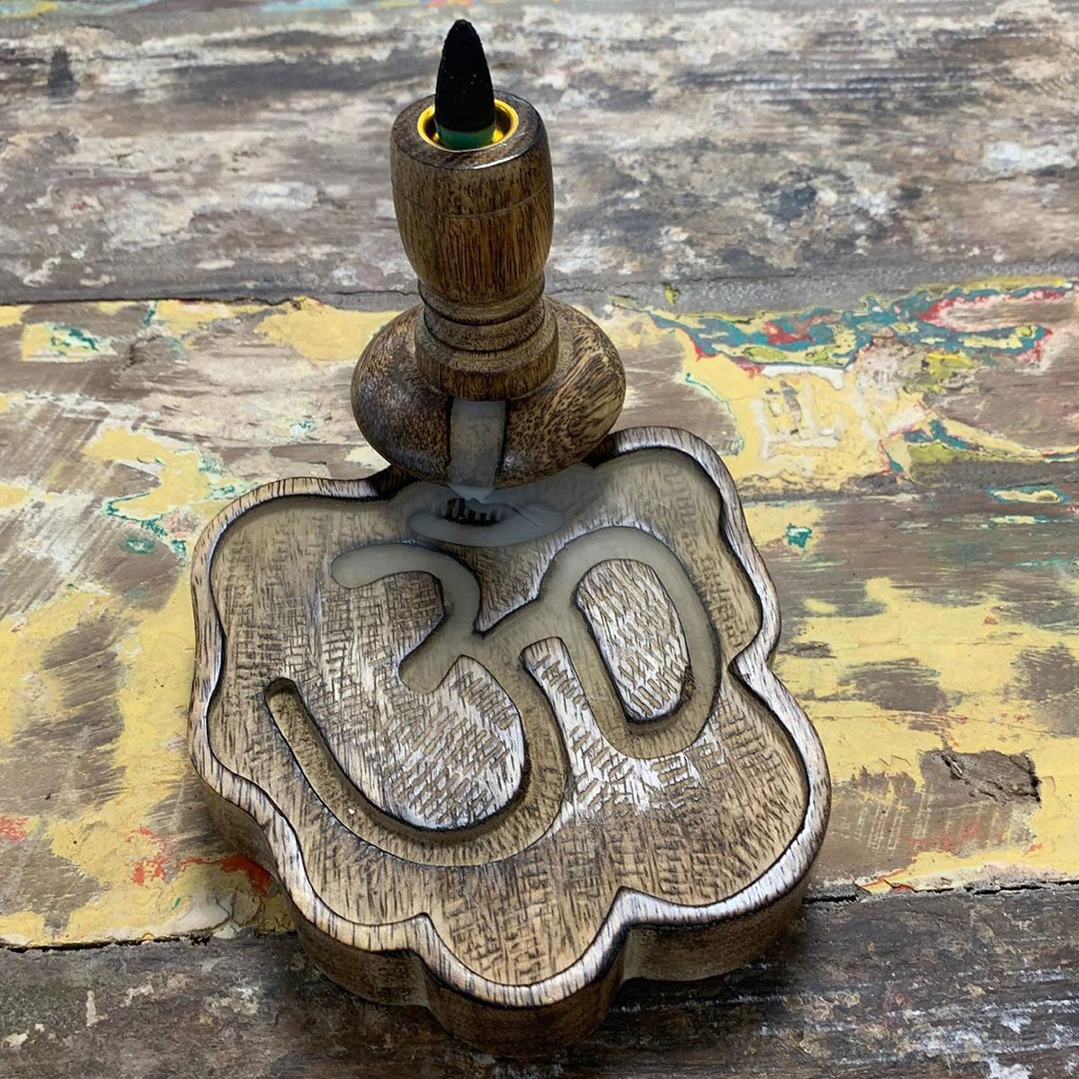 The Sm Mango Wood Backflow Burner - Ohm on a rustic wooden table, with smoke gently cascading downwards, creating a tranquil atmosphere at home. Ideal for relaxation and serenity. {{scent}} {{product_type}} – Christmas Gift Home Fragrance.
