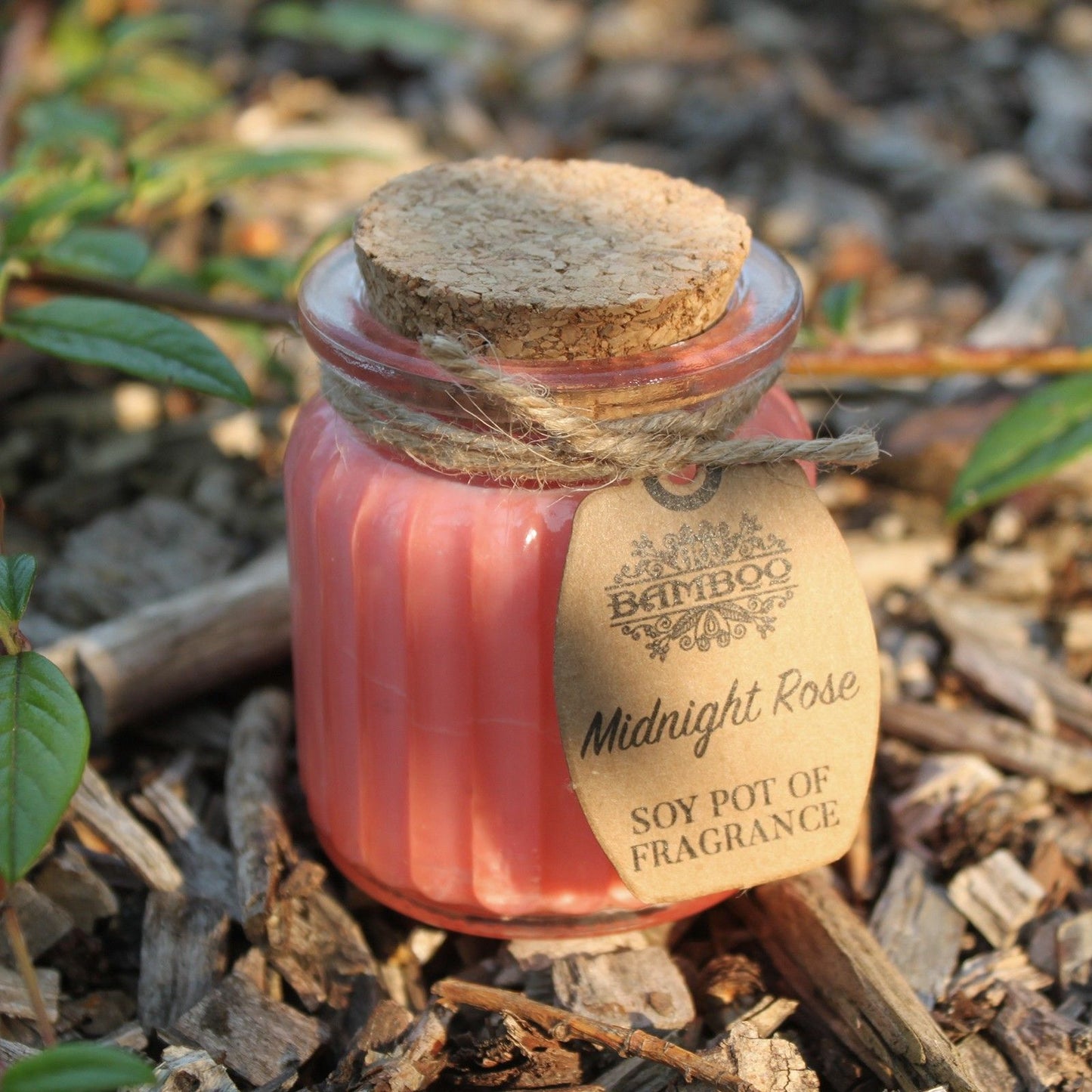 A close-up of the Midnight Rose Soy Candle in Glass Jar – Eco-Friendly Gift, nestled in natural surroundings, perfect for Christmas Gift Home Fragrance.
