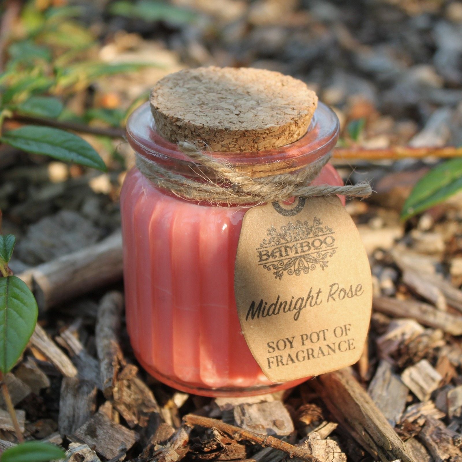 A close-up of the Midnight Rose Soy Candle in Glass Jar – Eco-Friendly Gift, nestled in natural surroundings, perfect for Christmas Gift Home Fragrance.