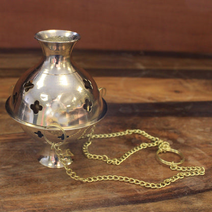 Hanging Brass Incense Burner - Ideal for Meditation & Rituals presented from an angle, highlighting its polished brass finish and intricate cut-outs. This elegant product enhances your meditation practice and is a great Christmas gift for those who appreciate home fragrance.