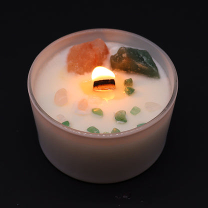Heart Chakra Rose Musk Candle lit, radiating warm light while revealing the beautiful crystals within. A perfect home fragrance option that makes for a thoughtful Christmas gift.