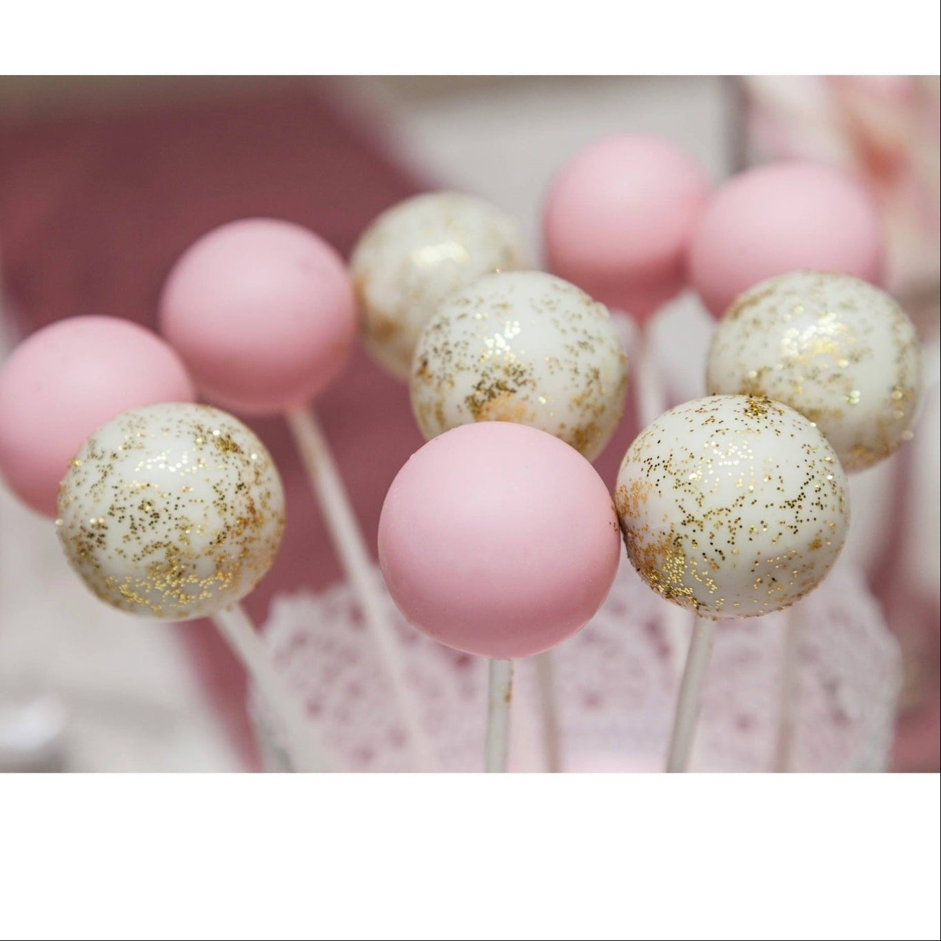 Close-up of pink and white glitter cake pops showing sparkle detail at luxury party setting